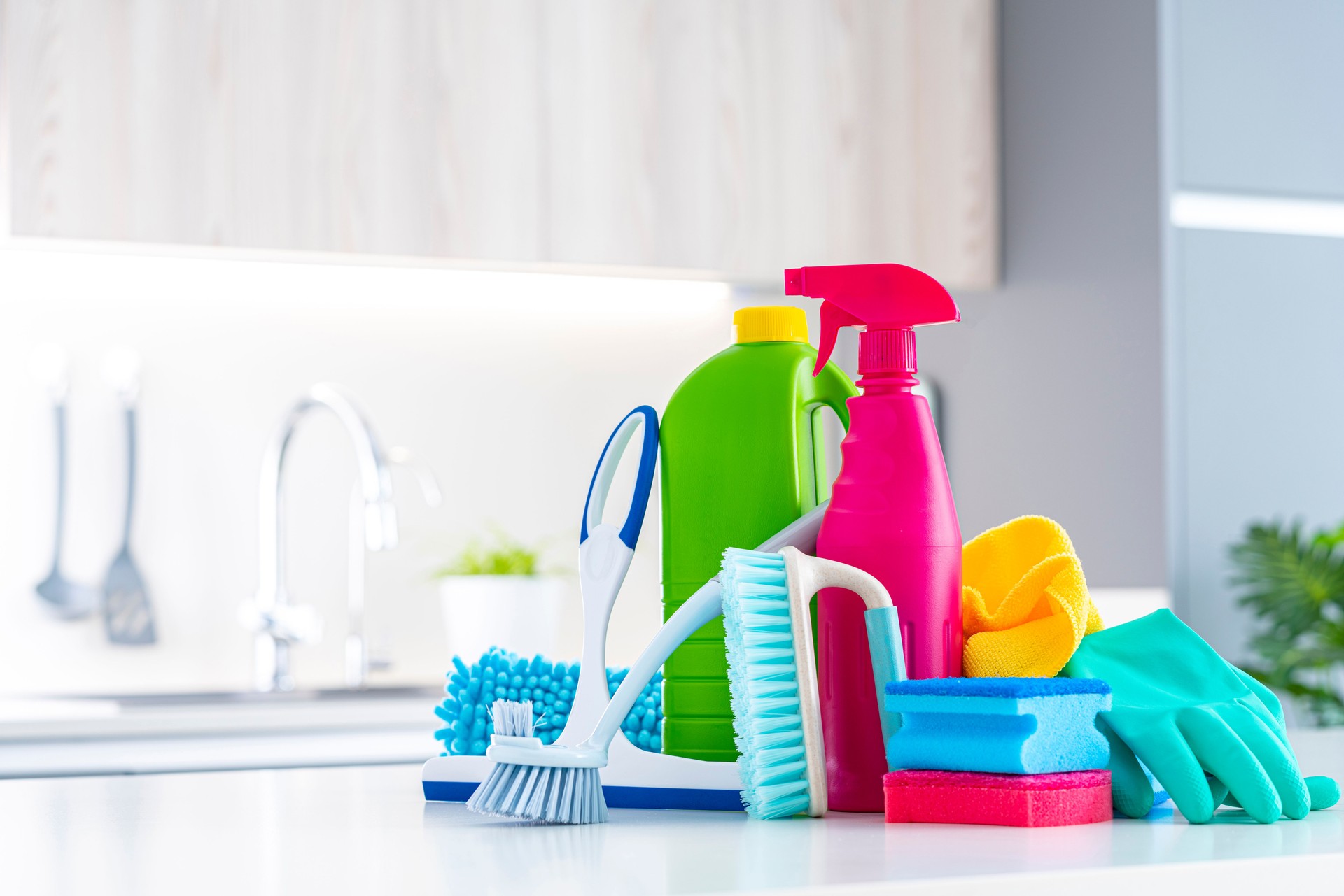 Colorful cleaning products and tools on kitchen counter